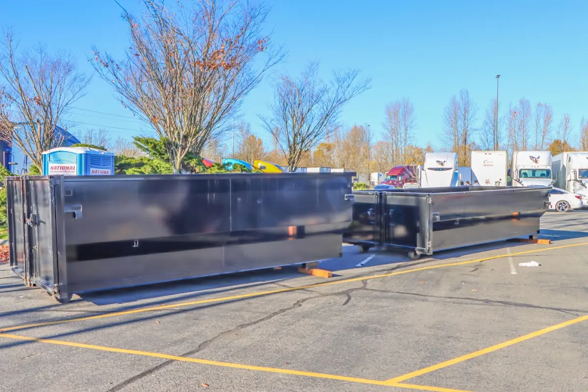 Professional dumpster rental service with roll-off container on residential driveway in Belle Plaine
